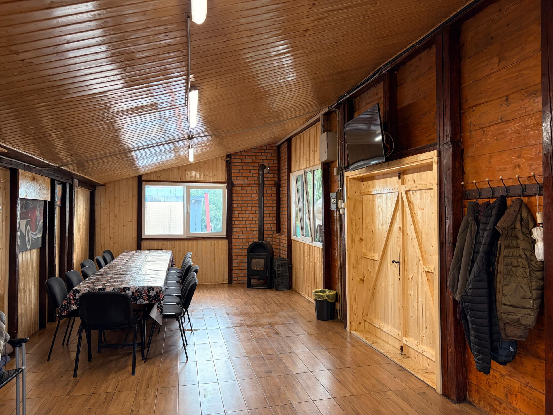 Interior rustic din lemn cu masă lungă pentru invitați